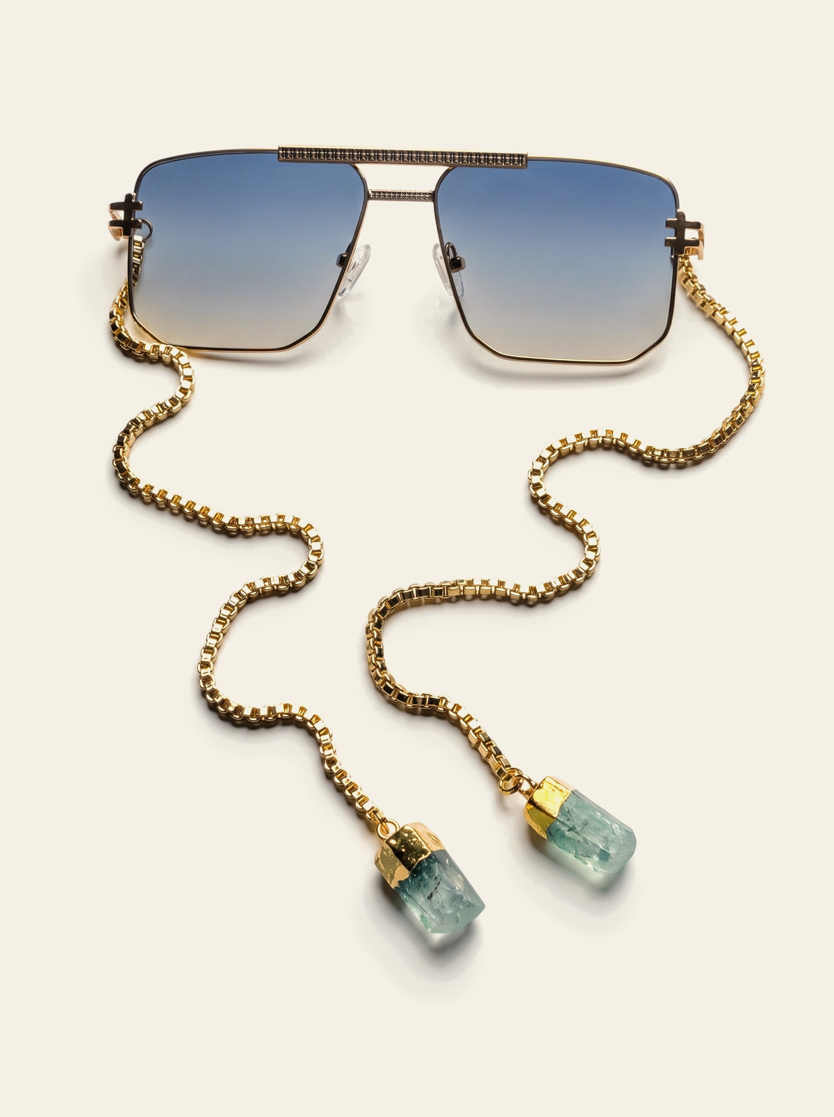 The Portofino - top view of the gold navigator frame with ribbed brow bar, blue-grey gradient lenses and hand-set green quartz chain