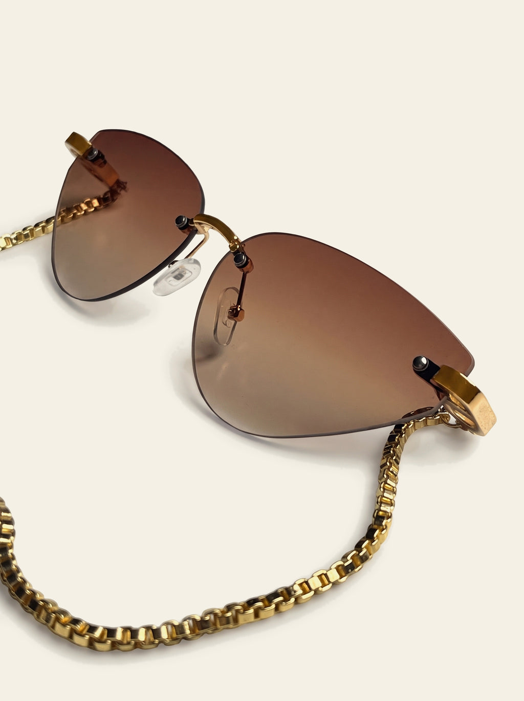 The Capri - close-up of the brown gradient lens fading from chocolate to warm tan, with the gold corner mount and box chain