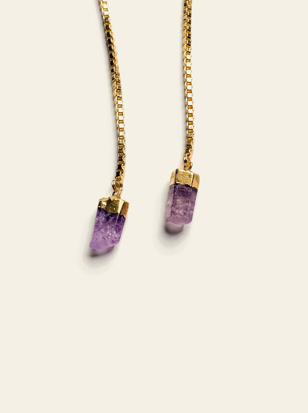 The Capri - close-up of two raw purple quartz stones hand-set in gold-dipped caps on an 18K gold-plated box chain
