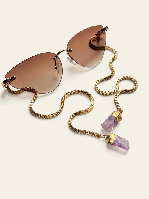 The Capri - top view of rimless cat-eye sunglasses with brown gradient lenses and a slim gold bridge, gold chain trailing forward