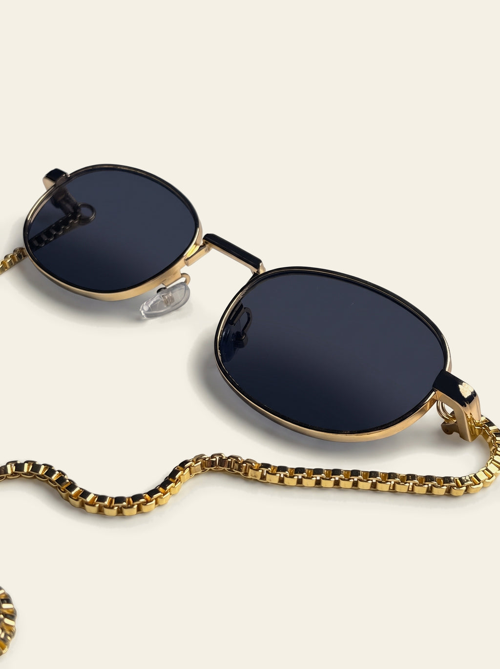The Amalfi - close-up of solid navy-black polycarbonate lens in a slim gold-finished oval rim