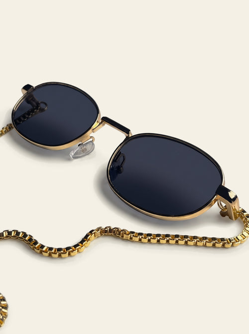 The Amalfi - close-up of solid navy-black polycarbonate lens in a slim gold-finished oval rim