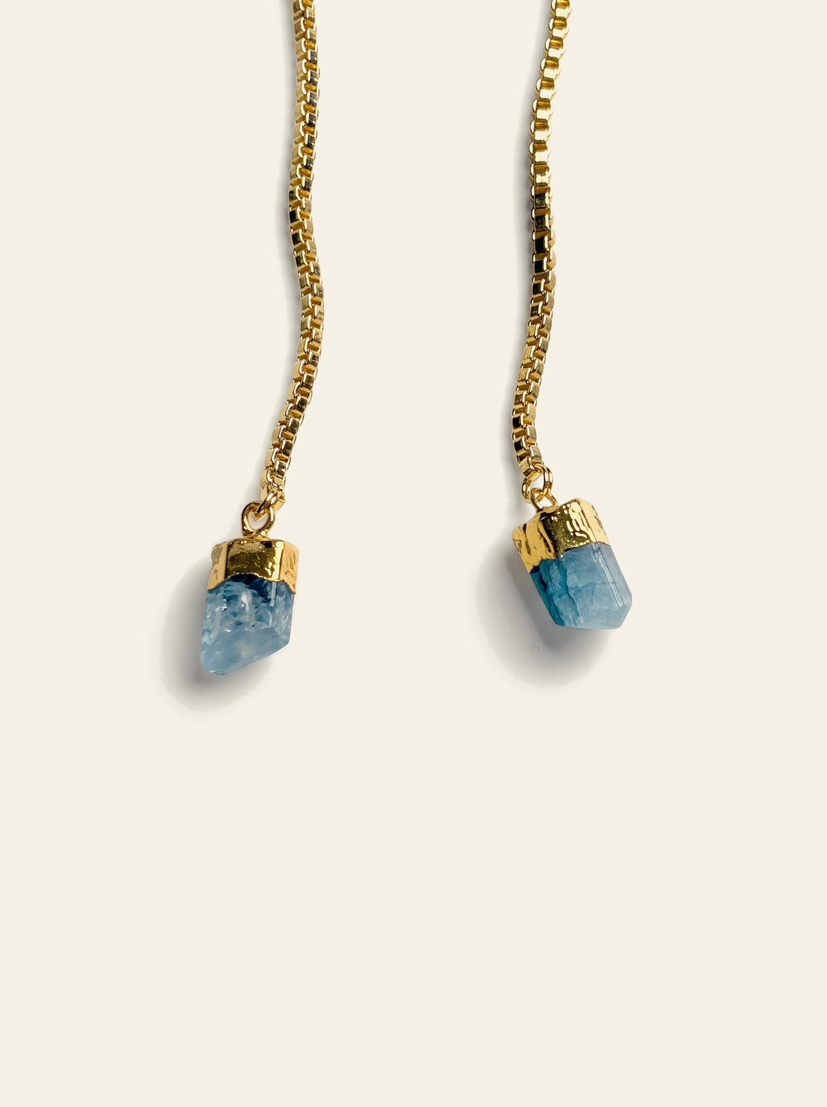 The Amalfi - close-up of two raw light-blue quartz stones hand-set in 18K gold-plated caps on a gold box chain