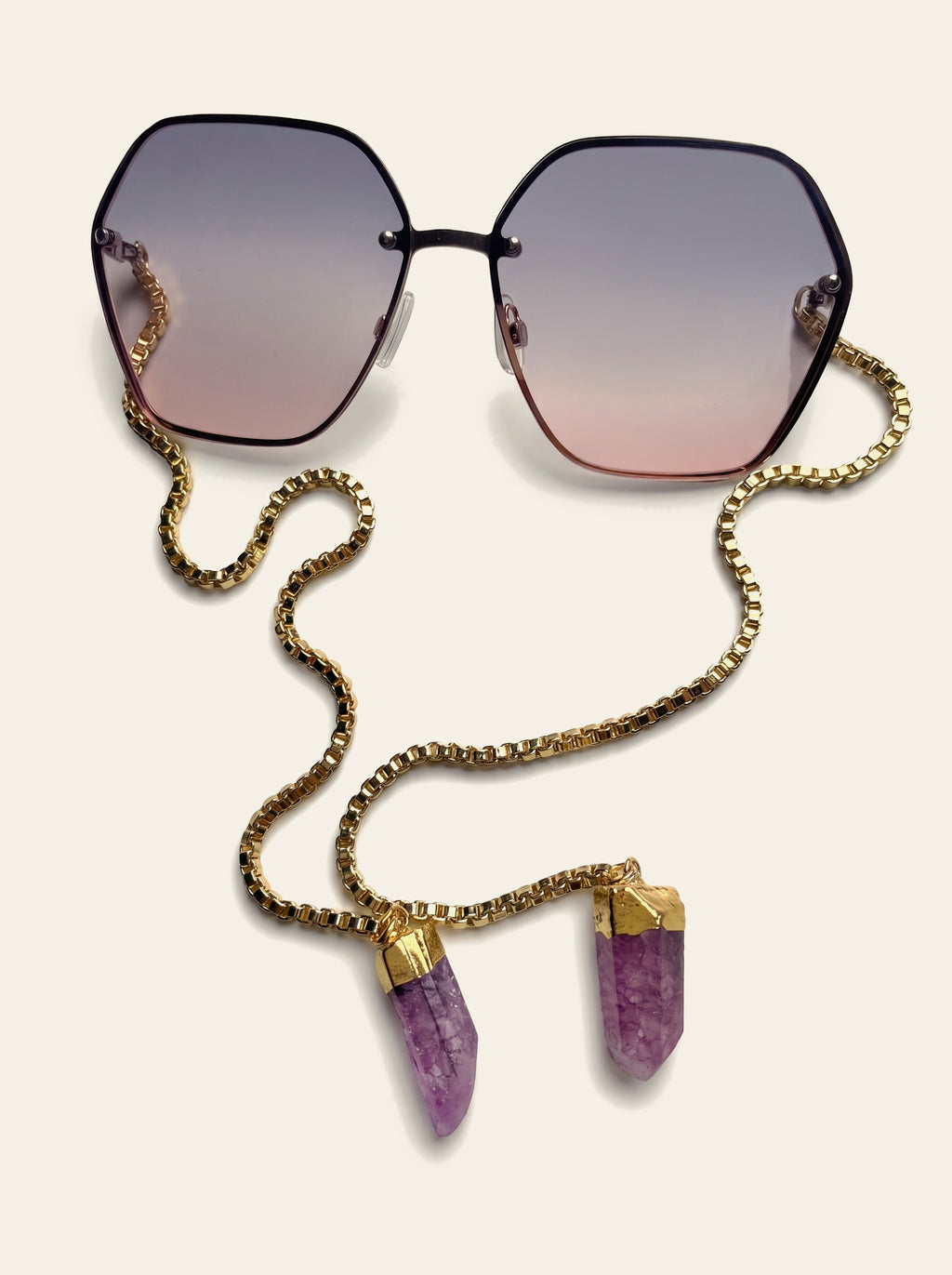 The Positano - top view of rimless hexagon lenses fading from grey-mauve to rose pink, gold box chain beneath