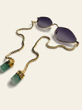 The Sorrento - thin gold diamond frame sunglasses with purple-grey gradient lenses and a gold box chain ending in two raw green quartz stones, three-quarter view