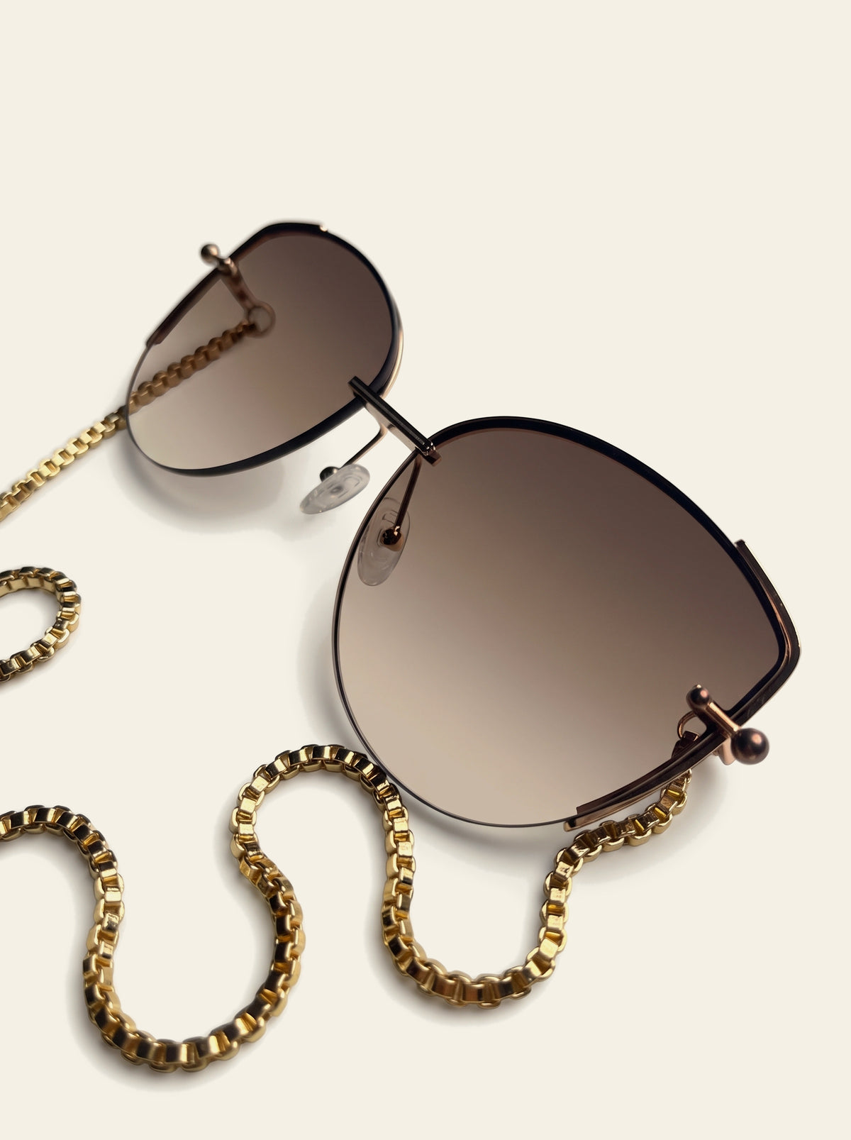 The Cannes - close-up of brown gradient lens fading from coffee brown to pale tan, with slim gold brow line and corner pin