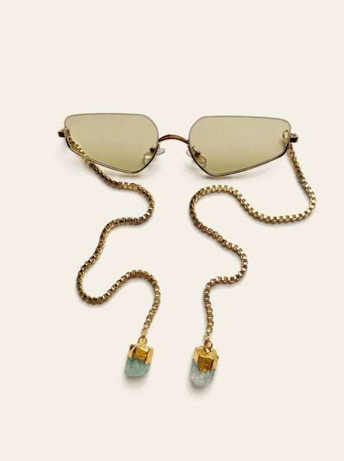 The Antibes - top view of rimless gold rectangle sunglasses with pale green lenses, gold box chain draped across the lens