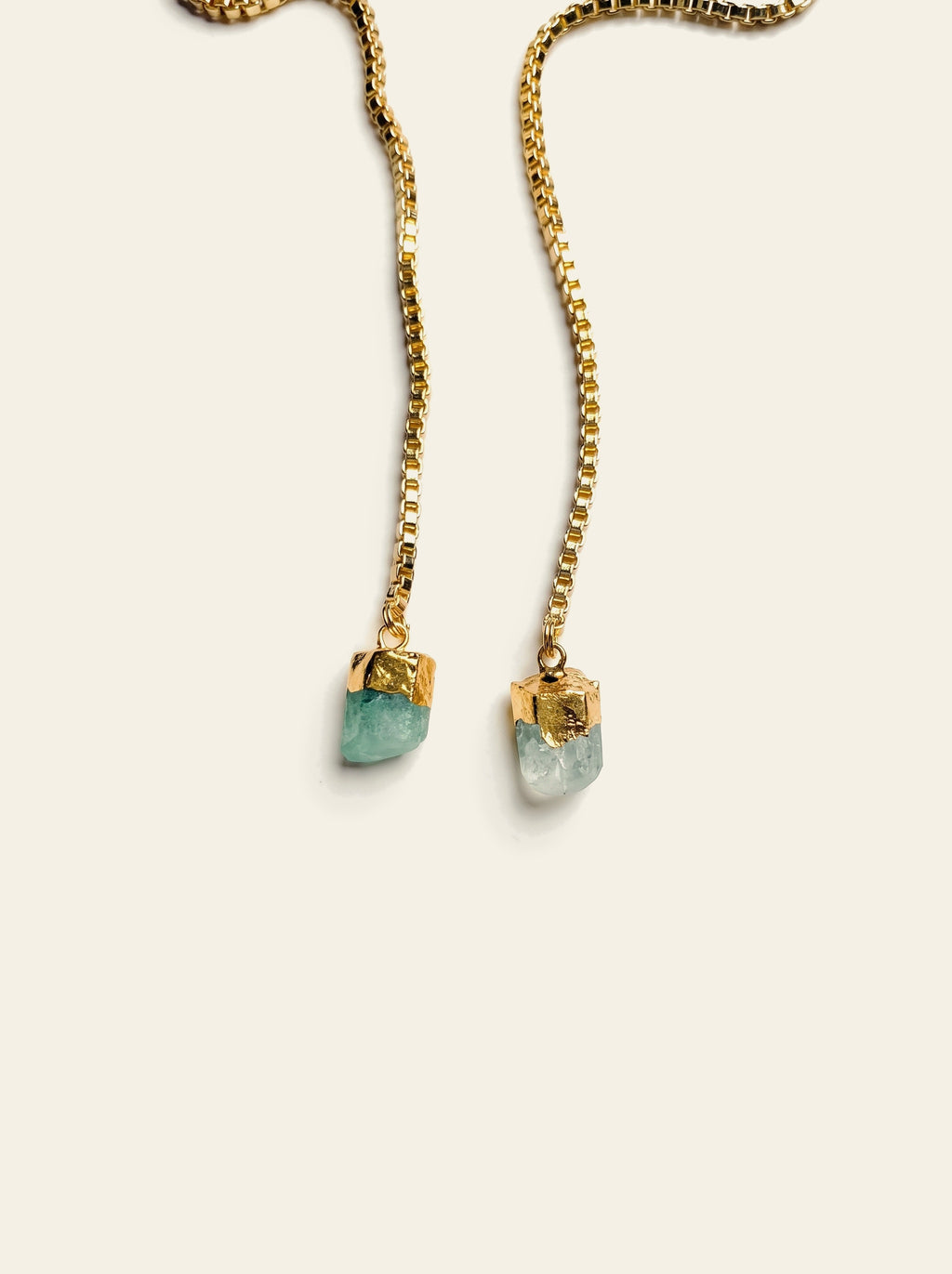 The Antibes - close-up of two raw mint green quartz stones hand-set in gold caps at the ends of the gold box chain