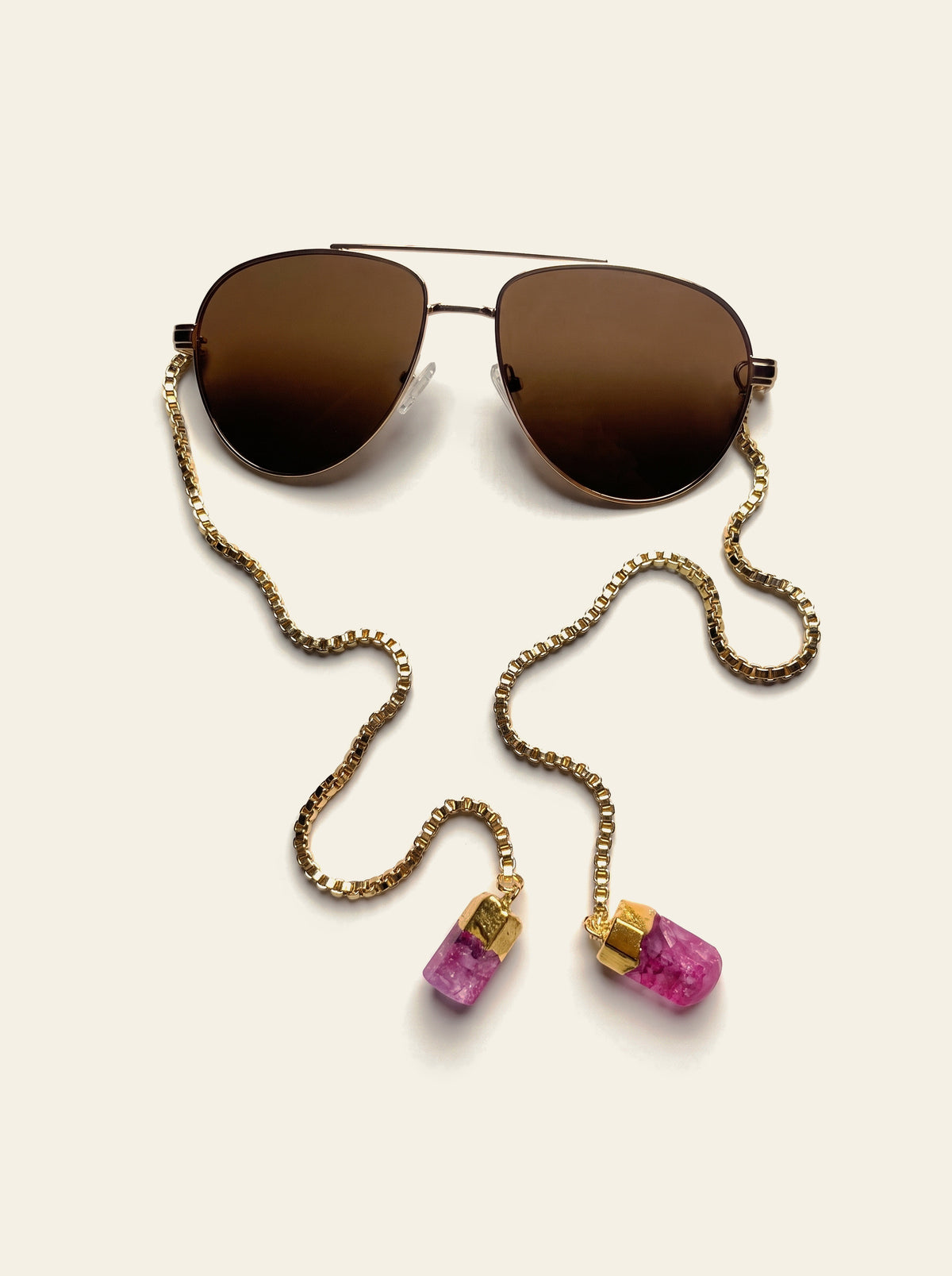 The Monaco - top view of the gold double-bridge aviator frame and brown gradient lens with the gold chain trailing away