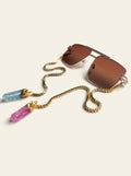 The Bellagio - gold navigator sunglasses with brown lenses, three-quarter view, gold chain draped to blue and pink raw quartz stones