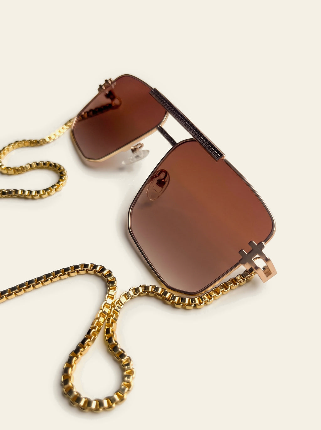 The Bellagio - close-up of the brown lenses and ribbed gold brow bar, chain falling to blue and pink quartz points