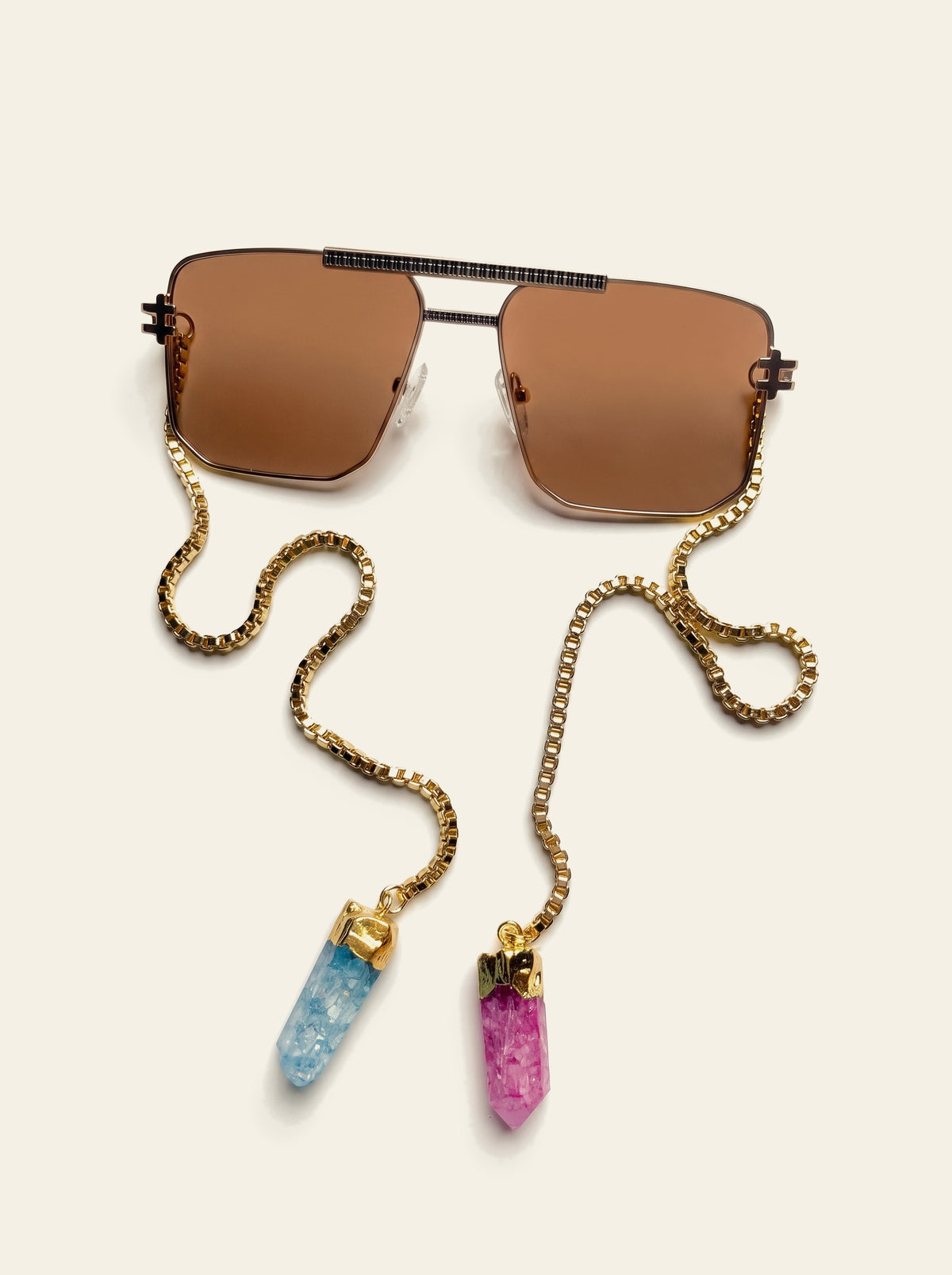 The Bellagio - top view of the gold navigator frame with ribbed brow bar and brown lenses, gold box chain coiled beside