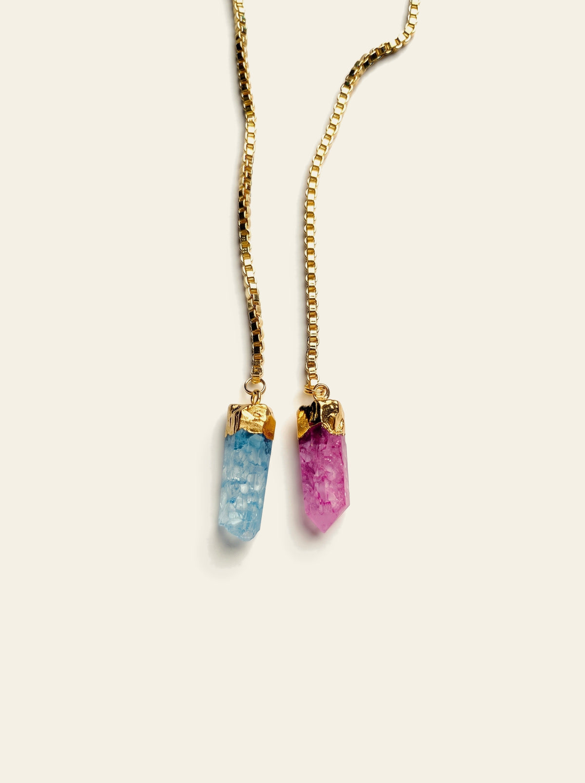 The Bellagio - close-up of one blue and one pink raw quartz stone, hand-set in gold-dipped caps on a gold box chain