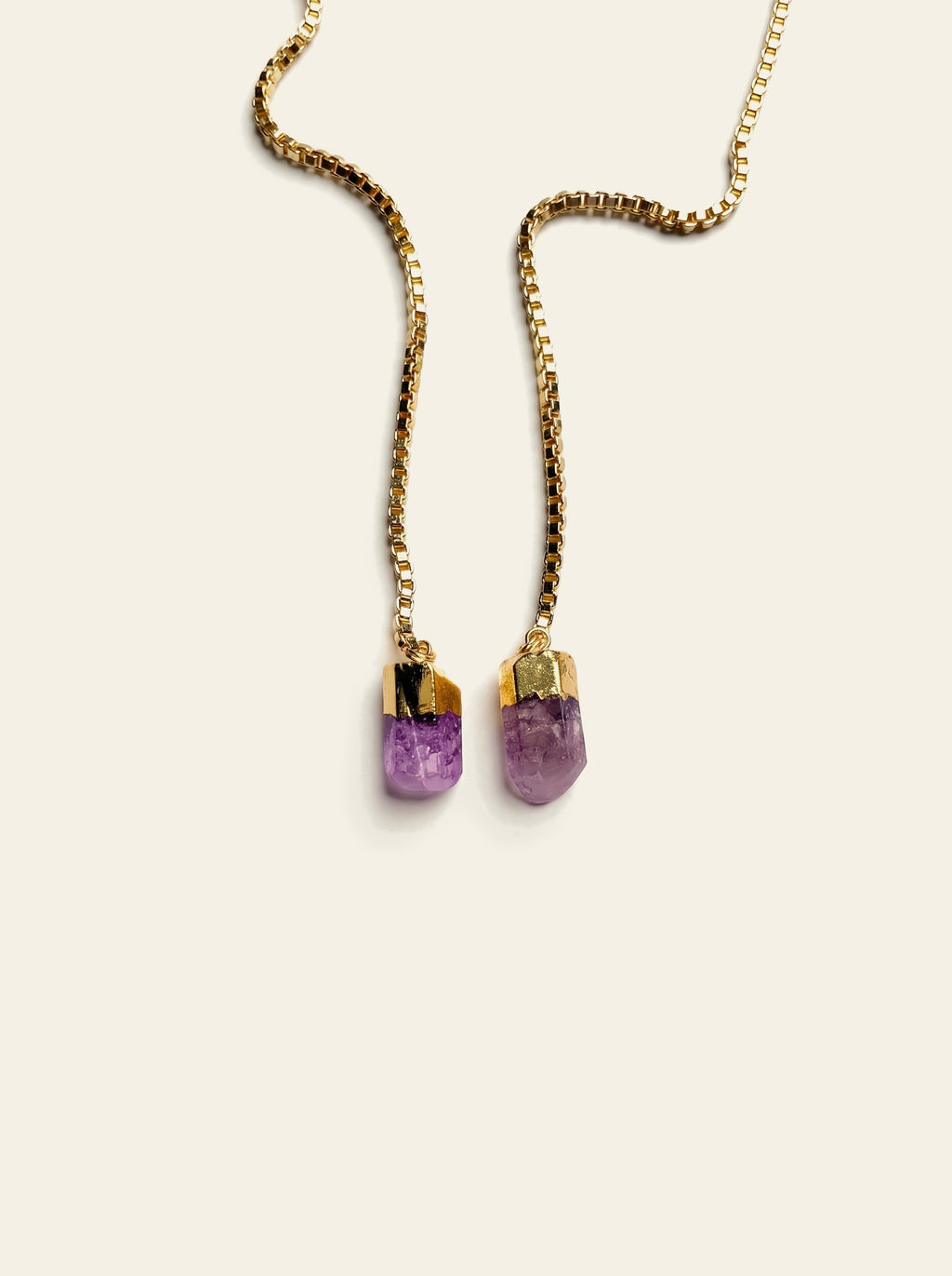 The Procida - close-up of two raw purple quartz stones, pale lilac with violet flecks, hand-set in gold-dipped caps on a gold box chain