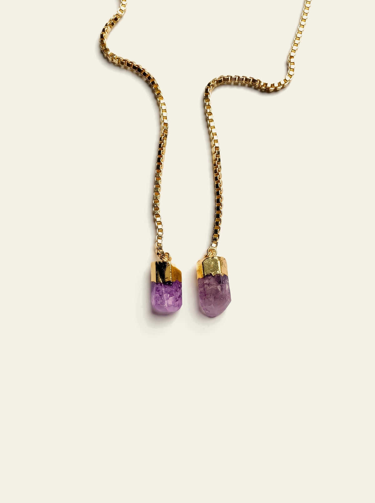 The Procida - close-up of two raw purple quartz stones, pale lilac with violet flecks, hand-set in gold-dipped caps on a gold box chain