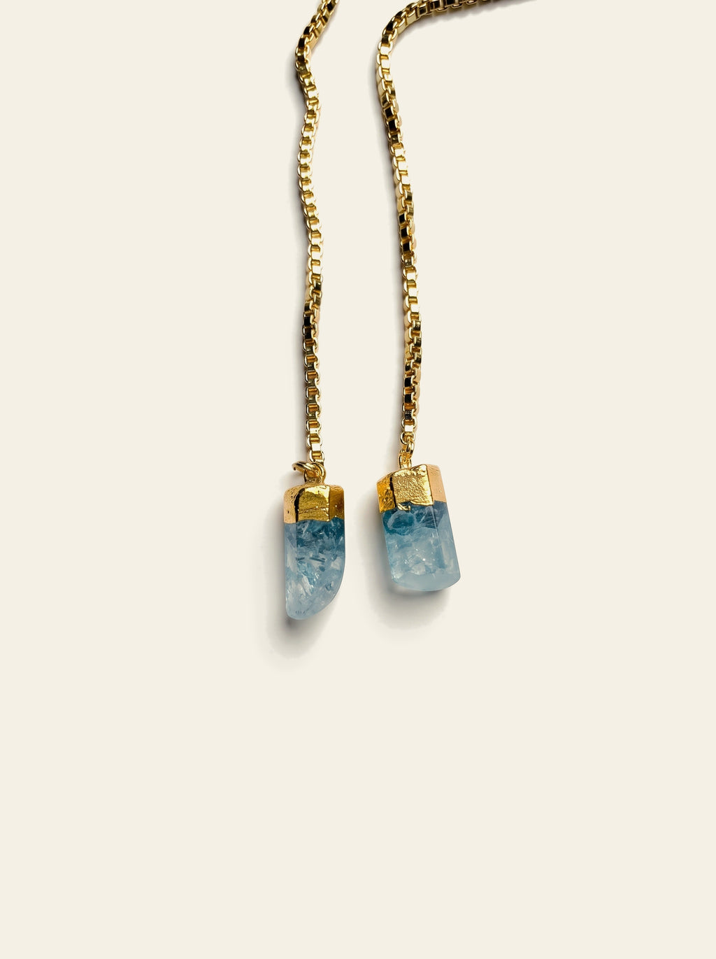The Rapallo - close-up of two raw pale blue quartz stones hand-set in gold caps on a gold box chain
