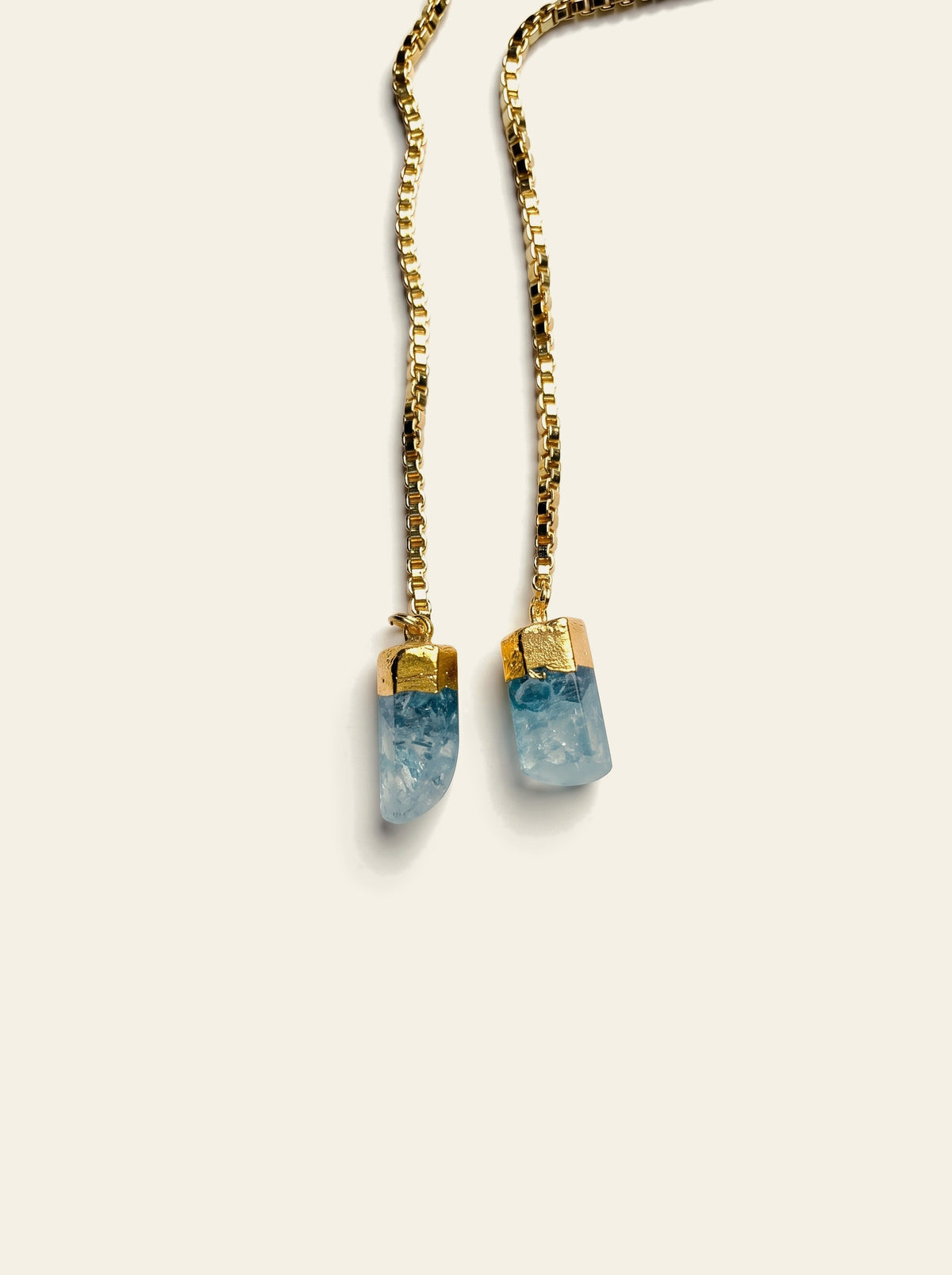 The Rapallo - close-up of two raw pale blue quartz stones hand-set in gold caps on a gold box chain