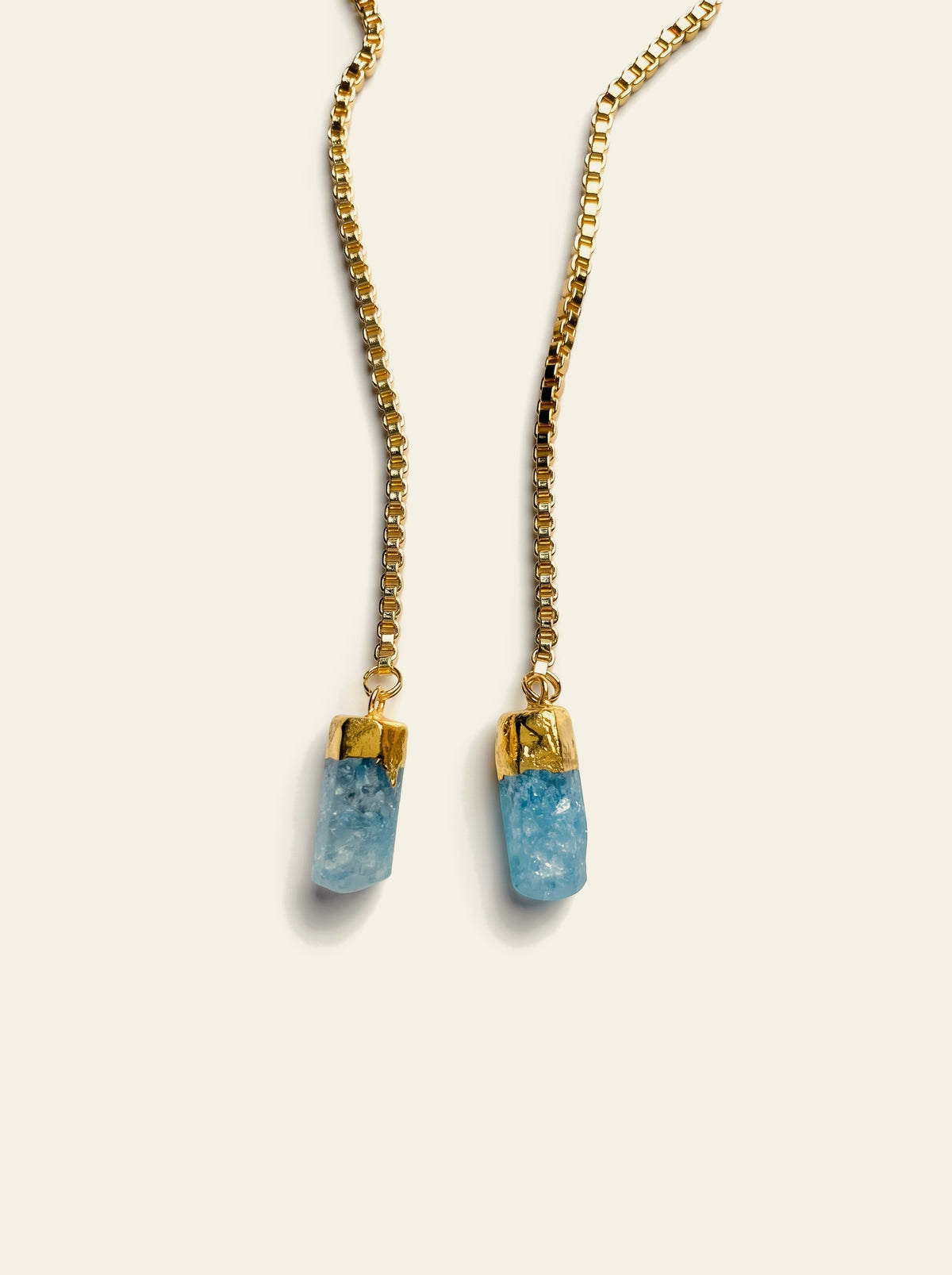 The Santorini - close-up of two raw blue quartz stones hand-set in gold-dipped caps on a gold box chain