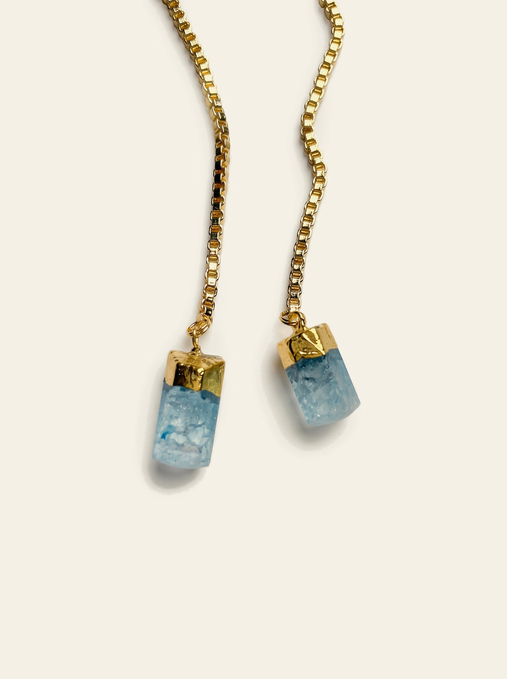 The Biarritz - close-up of two raw pale blue quartz stones hand-set in gold caps on a gold box chain