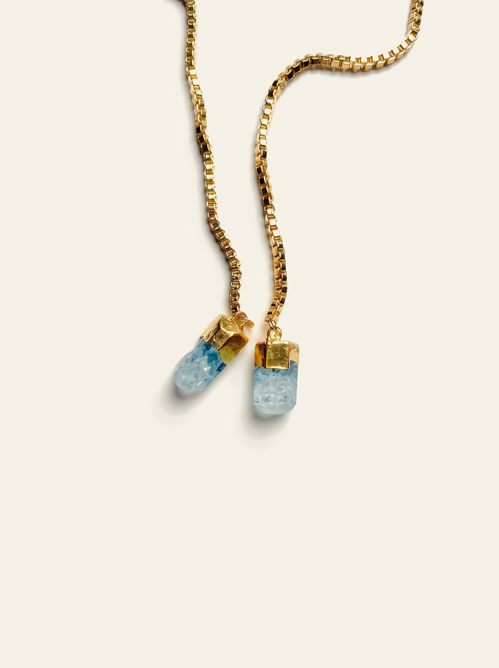 The Stresa - close-up of two raw pale blue quartz stones hand-set in gold caps on an 18K gold-plated box chain