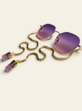 The Lipari - three-quarter view of gold thin-rim hexagon sunglasses with purple-to-pink gradient lenses and gold chain with two raw purple quartz stones